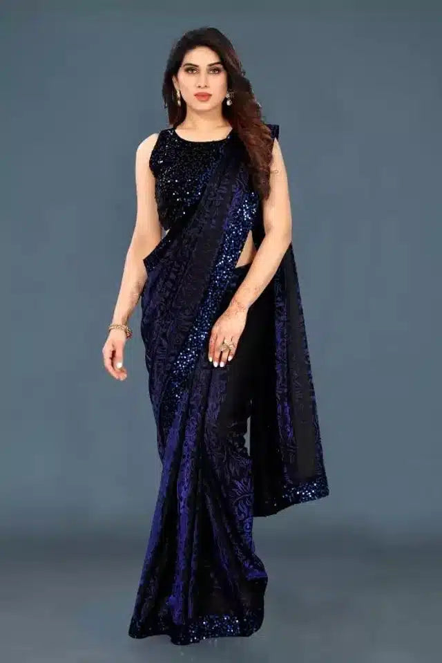 Woman wearing a dark blue saree with a matching blouse against a gray background