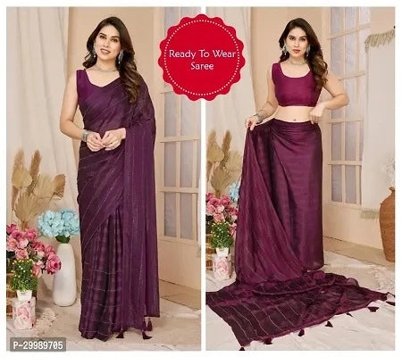 Woman wearing a purple saree with floral decorations and a neutral background